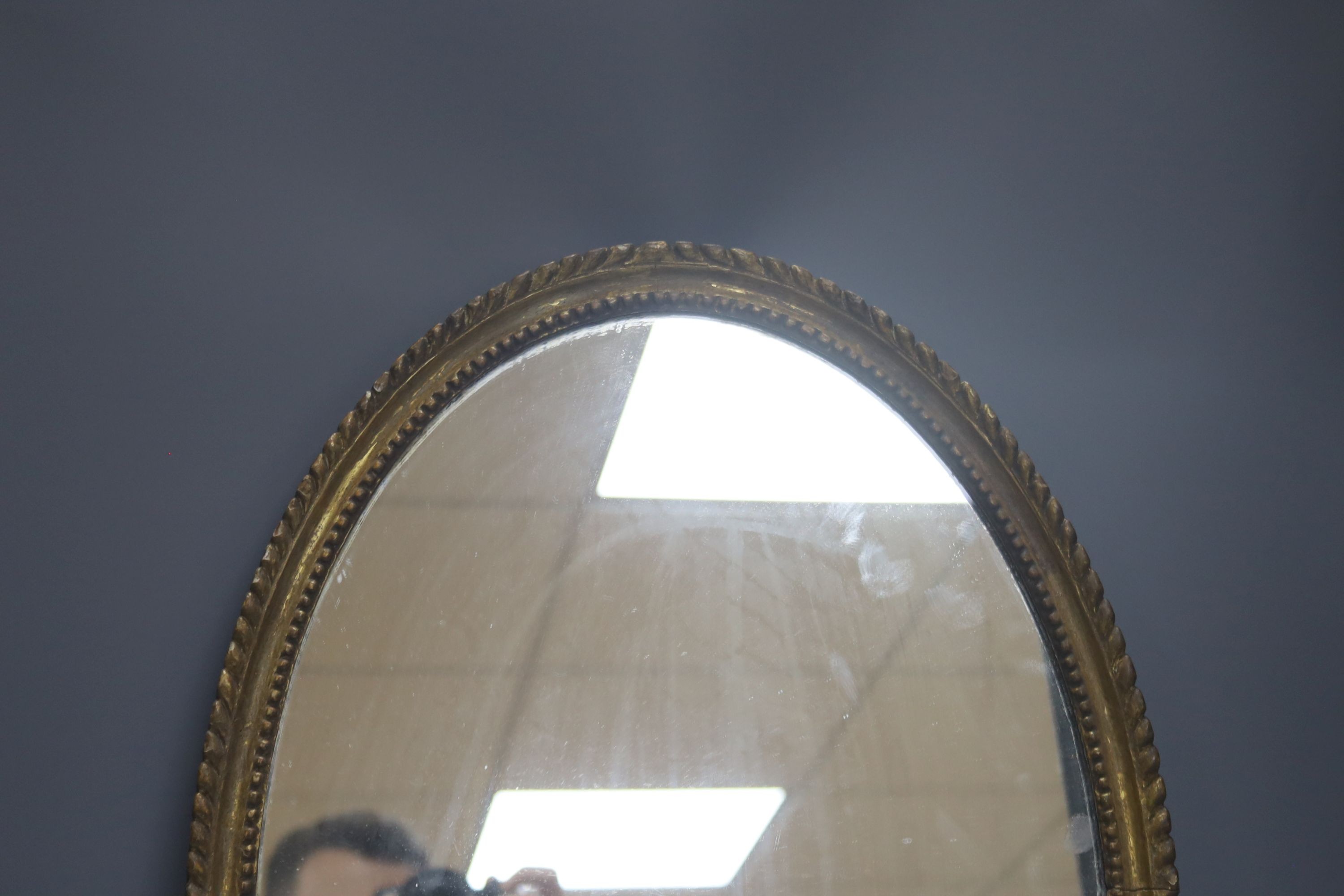 An oval gilt framed wall mirror, 55.5 cm high